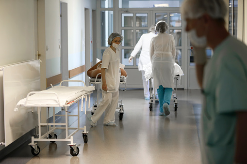 Doctors in white coats carry the patient on a stretcher. The real situation in the hospital.