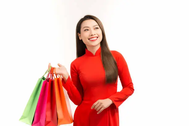 Asian women wearing traditional aodai clothes holding shopping bags