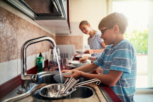 Kids washing up dishes after lunch Three kids washing up dishes in kitchen. The boys and a girl are working together to help their parents.
Nikon D850 wash dishes stock pictures, royalty-free photos & images