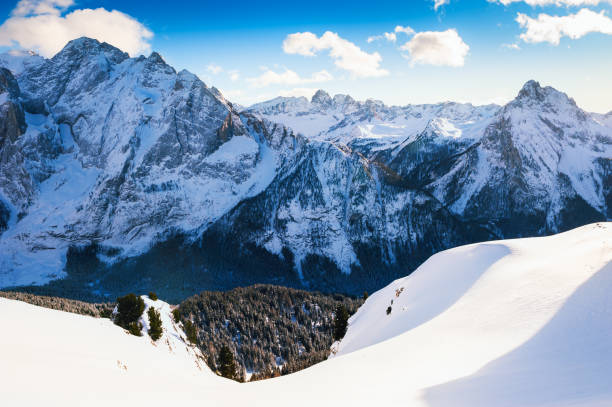 Snow-covered mountains in winter sunny day. Dolomite Alps. Val Di Fassa, Italy. Beautiful winter landscape