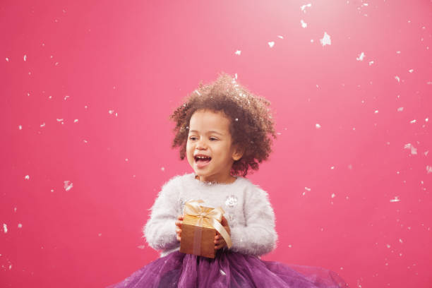 istock Cute little girl holding a shiny gift box 1187564007
