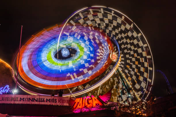 l'evento carnival of light al parco divertimenti linnanmaki. guida la ruota panoramica rinkeli e kehra in movimento, illuminazione notturna, lunga esposizione. - ferris wheel wheel blurred motion amusement park foto e immagini stock