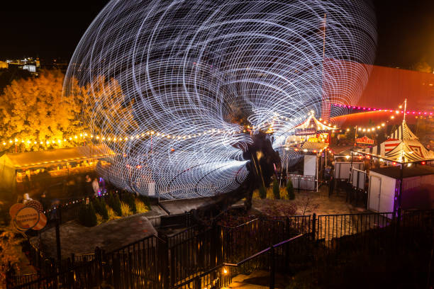 o carnaval do evento claro no parque de diversões de linnanmaki. monte magia em movimento, iluminação noturna. longa exposição. - ferris wheel wheel blurred motion amusement park - fotografias e filmes do acervo