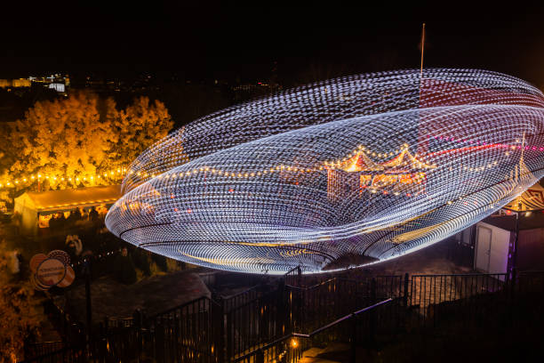 l'evento carnival of light al parco divertimenti linnanmaki. cavalca magia in movimento, illuminazione notturna. lunga esposizione. - ferris wheel wheel blurred motion amusement park foto e immagini stock