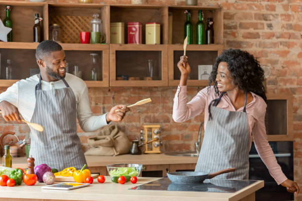 istock Funny married couple fighting with utensils tools in kitchen 1187568804
