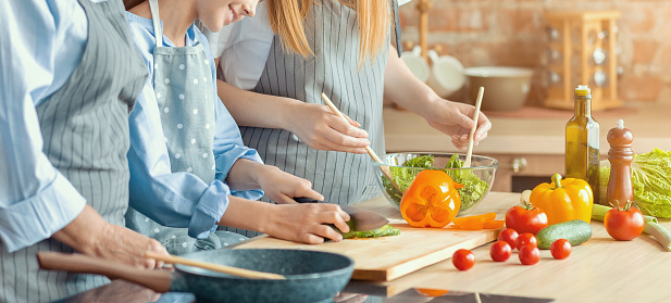 Healthy food concept. Cropped photo of three women cooking healthy meal together, panorama with free space