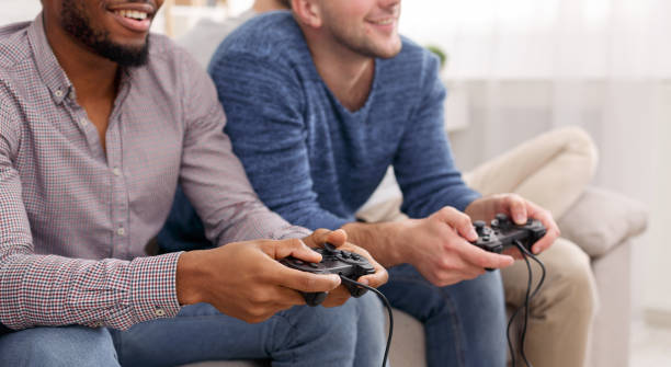istock Two mates holding joysticks, playing video games 1187570574