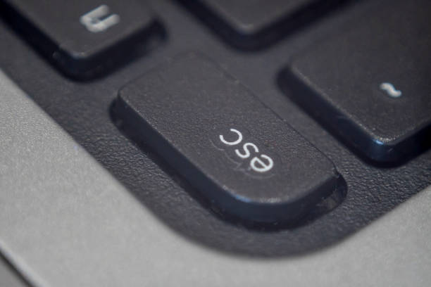 Close up of the esc key on a keyboard Extreme macro of the escape key on a laptop keyboard. Escape concept. escape key escape computer push button stock pictures, royalty-free photos & images