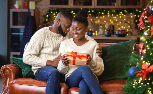 istock Caring african american man presenting Christmas gift to his girlfriend 1187573308