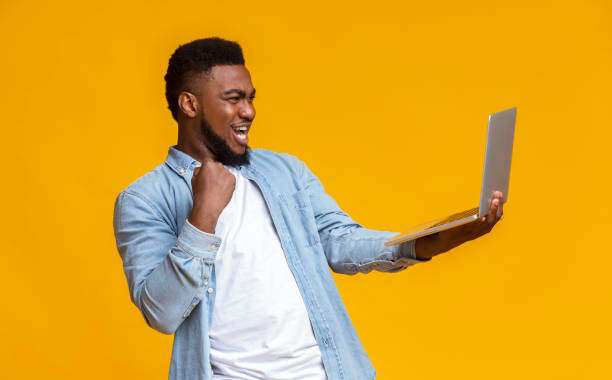 istock Black Guy Celebrating Win With Laptop, Shouting And Clenching Fist 1187574587