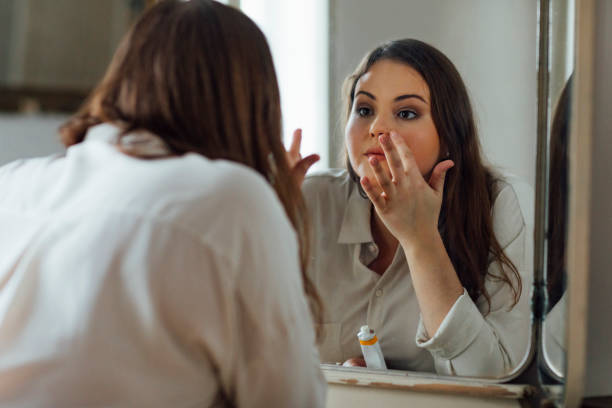 istock Woman Applying Face Cream 1187574727