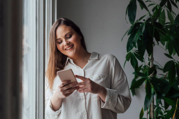 istock Pretty Plus Size Woman Using her Cell Phone 1187574751