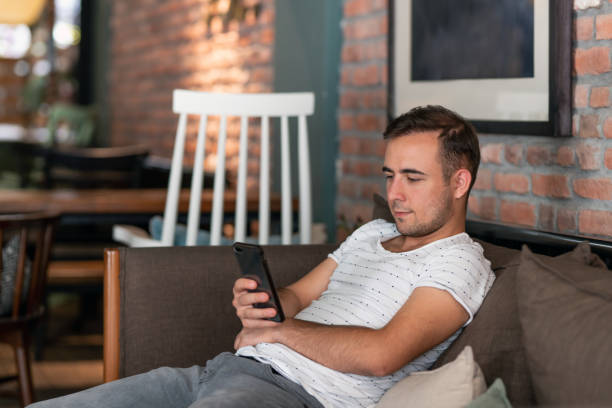 istock A young man watching videos on the internet using his smartphone 1187575709