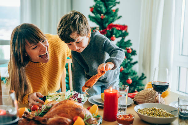 istock Happy mother and her son having fun while holding roasted turkey leg 1187576097