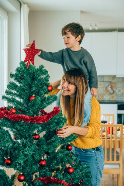istock Mother and son putting star on Christmas tree 1187576107