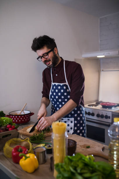 istock Handsome man cooking vegetable salad in kitchen 1187576526