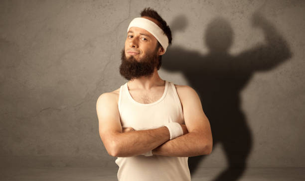 istock Skinny man with musculous shadow 1187577263