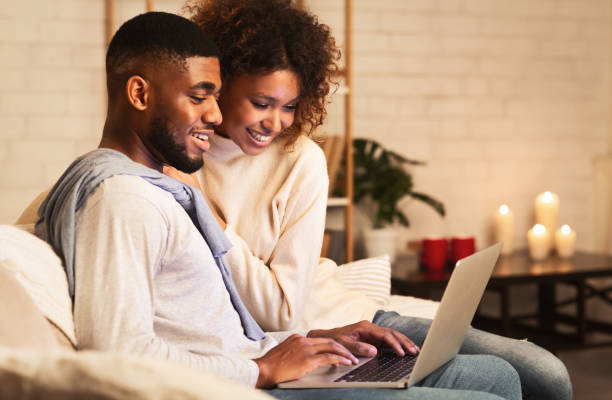 istock Young married couple using laptop at cozy winter evening 1187579071