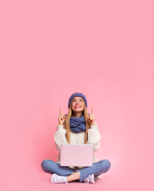 istock Girl with laptop showing up at empty space 1187579216
