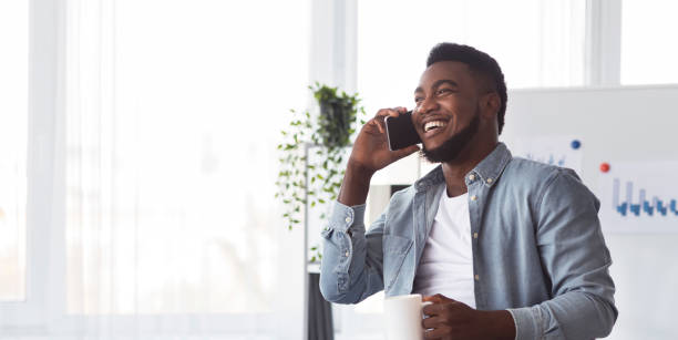 istock Black worker calling to friends during working hours in office 1187579491
