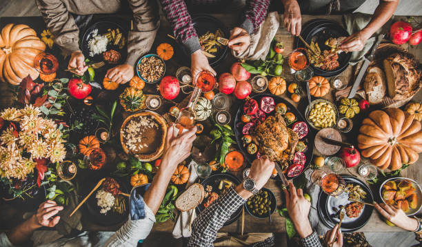 istock People eating and pouring wine at Thanksgiving celebration dinner table 1187579620