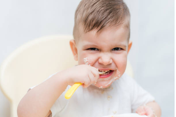 istock cute toddler eating a pumpkin with a small spoon himself 1187580491