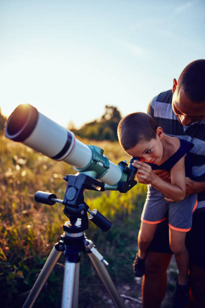 istock Father and son observing the sky with a telescope. 1187580981