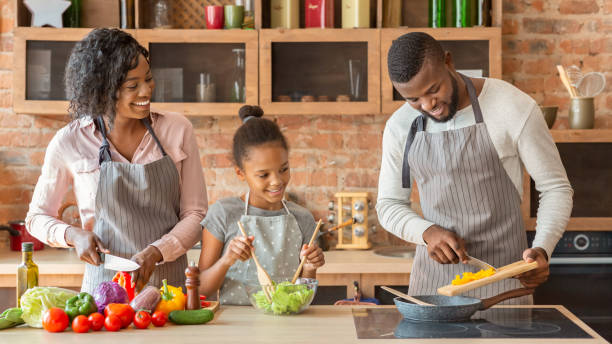 istock Mom and daughter watching dad while cooking together 1187581252