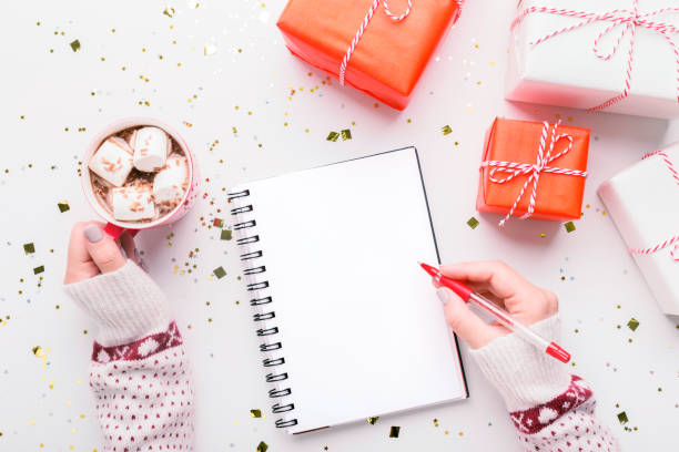 istock Woman writing New Year greetings in notebook on background 1187581890