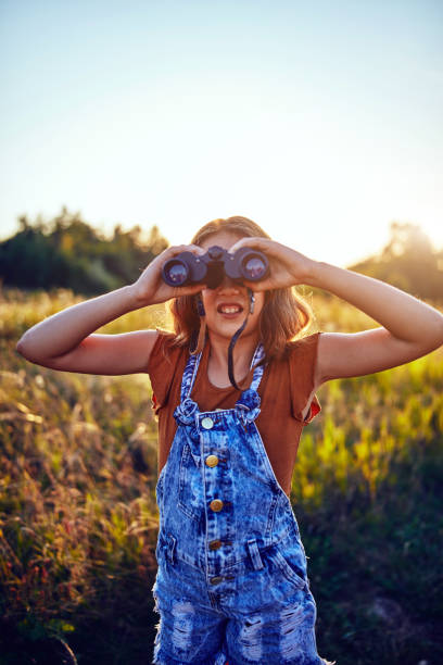 istock Little girl using binoculars in the nature. 1187582180