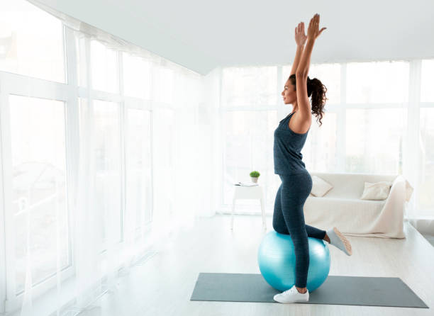 bella ragazza sportiva che fa esercizi con palla in forma a casa - yoga ball foto e immagini stock