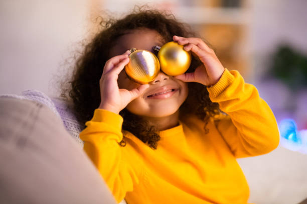 petite fille noire mignonne jouant avec des billes pour l'arbre de noel - christmas child baby surprise photos et images de collection