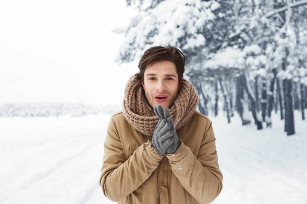 istock Happy Guy In Gloves Rubbing Hands Standing In Winter Forest 1187583729