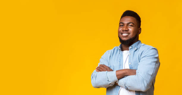 istock Attractive black guy with folded arms over yellow background 1187583918