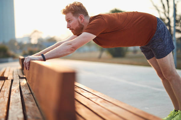 istock Young man exercising / stretching in urban park. 1187585150