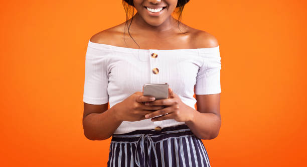 istock Afro Woman Using Smartphone Standing Over Orange Background, Cropped, Panorama 1187586412