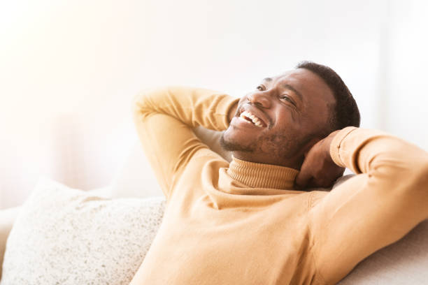 istock Guy Sitting On Sofa Holding Hands Behind Head At Home 1187587449