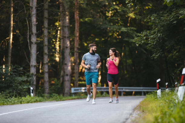 istock Young couple jogging in nature 1187588746