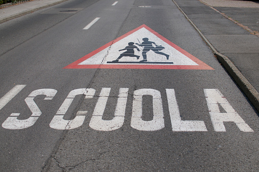 Atención niños que cruzan para el letrero de la escuela dibujado en la calle photo