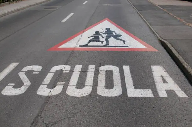 Picture of a huge attention children crossing for school (scuola) warning sign drawn on a street in Caslano, Switzerland