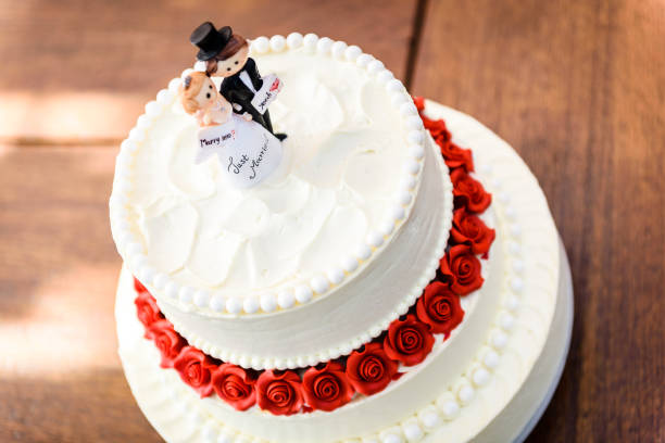istock White wedding cake with bride and groom figurines on top. 1187593210