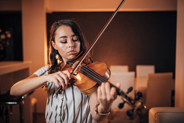 istock Young woman playing violin 1187596449
