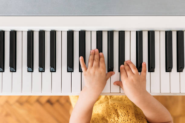 A Child Playing Piano From above photo of hands of unrecognisable little girl playing a piano. preschooler caucasian one person part of stock pictures, royalty-free photos & images