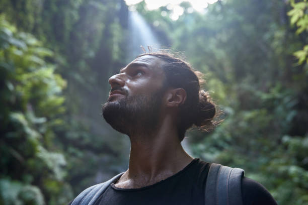 istock Young man looks up pensively at the trees 1187599279