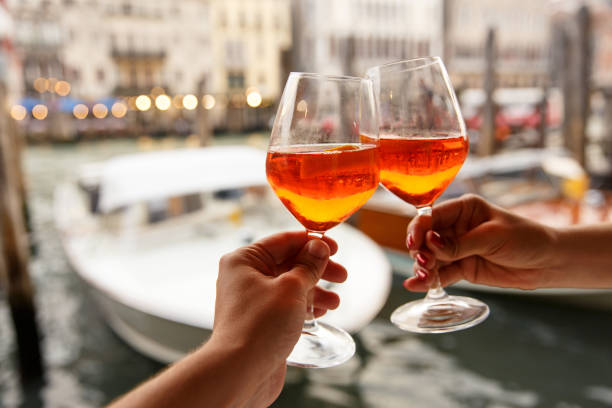 pareja de vasos con aperol spritz en venecia, italia - clunking fotografías e imágenes de stock