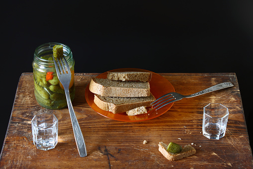 Feast for two. Vodka, black bread, salted cucumber on a wooden background. Binge and  appetizer in Russian style