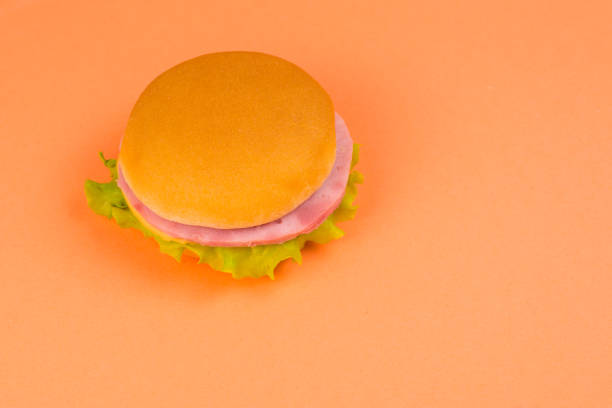 istock Sandwich with ham, cheese, lettuce on orange background. 1187609964