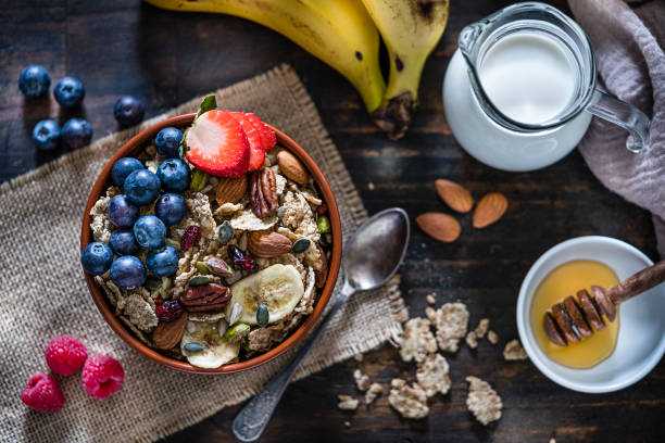 Healthy breakfast. Fresh porridge, with strawberry, banana and nuts in a bowl on white background. Top view.