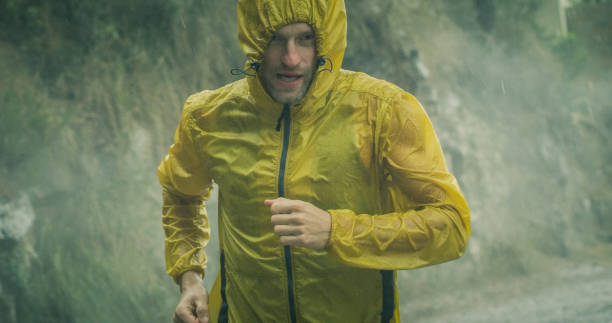 homme athlétique faisant le jogging dans l'état extrême de temps. grêle et pluie - courir sous la pluie photos et images de collection