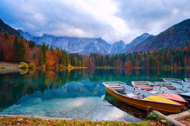 Alpine lake and colorful boats, Lake Fusine,Italy stock photo